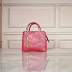 Front view of embossed maroon koi leather shoulder handbag with tassel