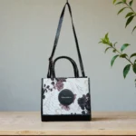 Front view of black floral printed crossbody handbag
