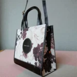 Side view of fabric floral printed crossbody handbag in black