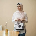 Fabric floral printed crossbody handbag in black worn by a model