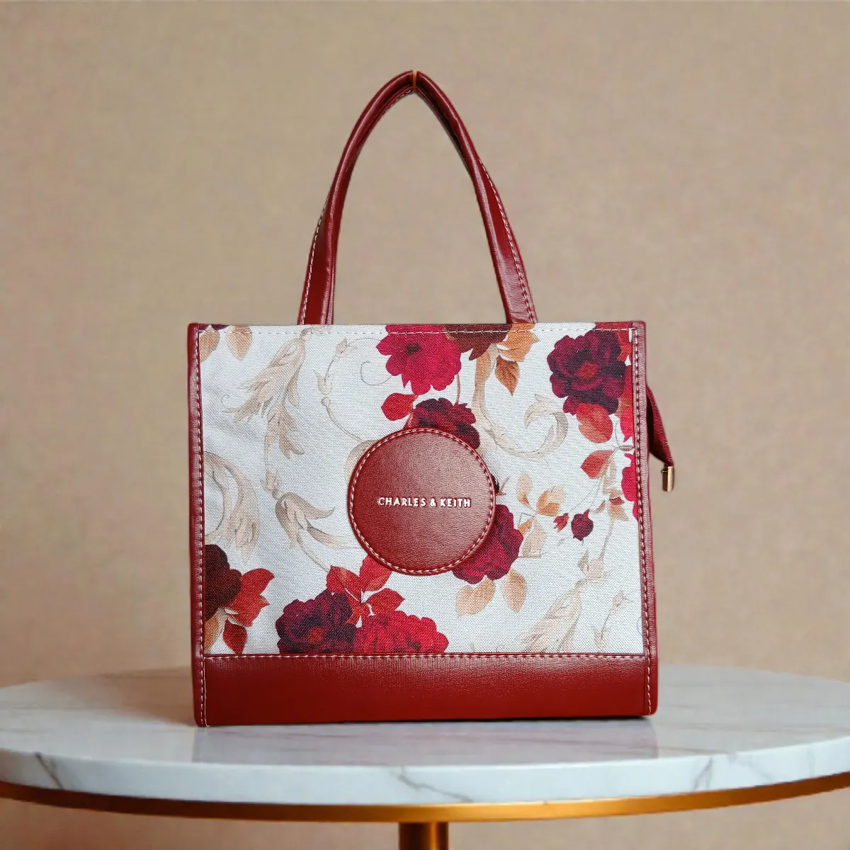Floral printed maroon crossbody handbag front view with short handles and long strap