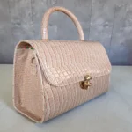 Glossy beige croc handbag angled side view