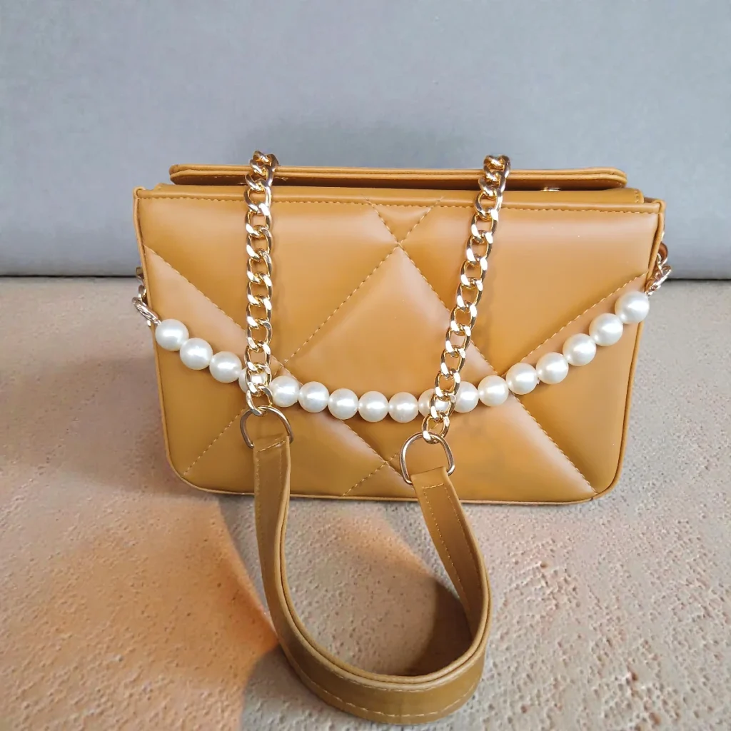 Front view of camel quilted crossbody handbag with pearl chain and gold chain strap
