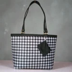 Black and white houndstooth printed ladies tote bag with long black shoulder straps and detachable zip pouch