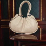 Drawstring handbag back view with gathered top and short handles