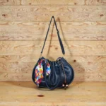 Navy blue handbag with scarf accent and hanging charm