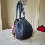 Side view of navy blue soft drawstring handbag