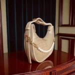 Beige textured crossbody bag side angle showing pearl detail