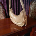 Beige pearl detail crossbody bag on table front angle
