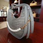 Grey pearl detail crossbody bag showing side thickness