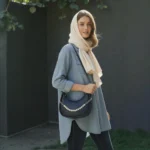 Navy blue crossbody bag worn by model for size reference