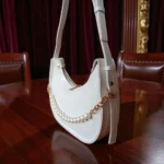 White textured crossbody bag showing adjustable long strap