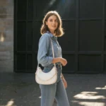 White textured crossbody bag worn on shoulder by model