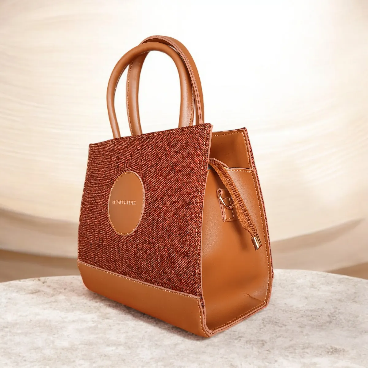 Brown tweed crossbody handbag side angled view showing textured material and leather trim