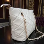 Angled side view of Ivory Cream diamond quilted tote with gold chain detailing