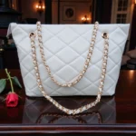 Classic Quilted Chain Strap Tote Bag Pearl White with diamond quilted pattern and gold chain shoulder straps displayed on wooden table with red rose decor