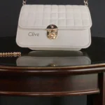 Side profile of embossed grid leather flap chain crossbody bag in ivory white highlighting depth and structure