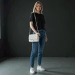 Embossed grid leather flap chain crossbody bag in ivory white styled on model for casual outfit look