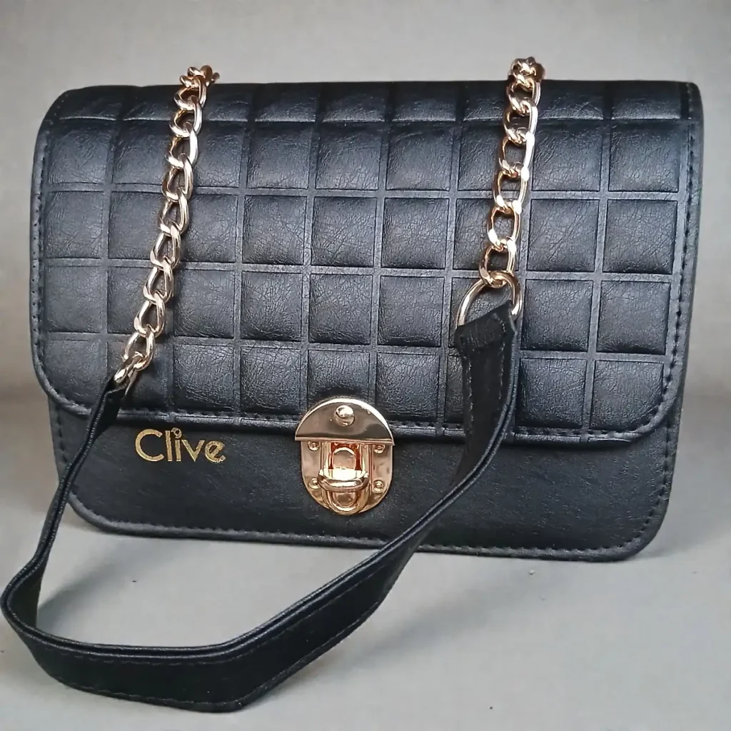 Front flap view of jet black grid embossed leather crossbody purse with gold lock and chain strap