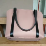 Minimal Contrast Strap Tote Handbag – Blush Pink bottom view with protective metal studs and black contrast shoulder straps
