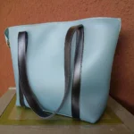 Minimal contrast strap tote handbag dusty blue side angle showing depth and structure