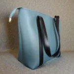 Contrast strap tote handbag dusty blue colour side profile with structured base