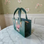 Printed Portrait Mini Structured Top Handle Crossbody Emerald Green angled view highlighting structured shape portrait print and metallic handle fittings