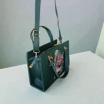 Printed Portrait Mini Structured Top Handle Crossbody Emerald Green hanging with adjustable strap and top handle showing crossbody styling option