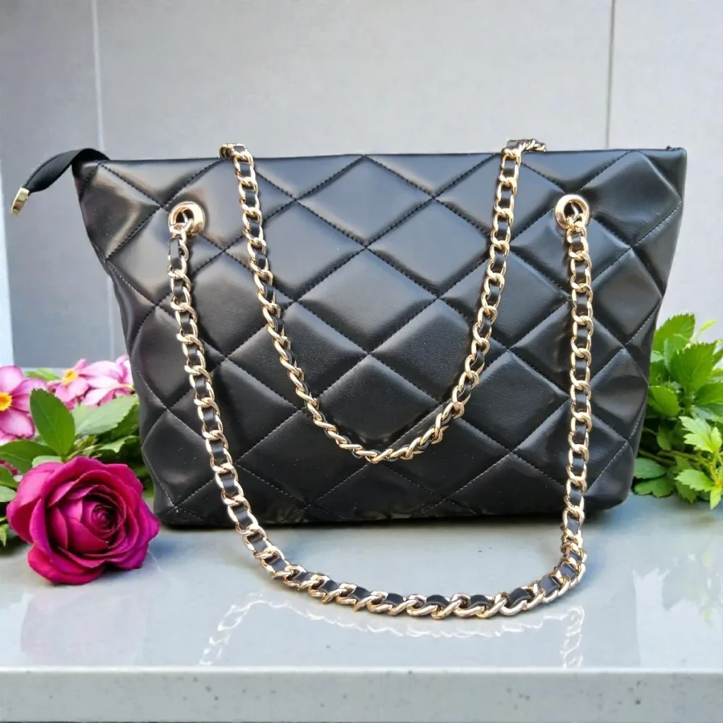 Classic Quilted Chain Strap Tote Bag – Jet Black displayed on a marble surface with gold chain straps and diamond quilted faux leather finish styled with a red rose and greenery in the background