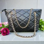 Classic Quilted Chain Strap Tote Bag – Jet Black displayed on a marble surface with gold chain straps and diamond quilted faux leather finish styled with a red rose and greenery in the background
