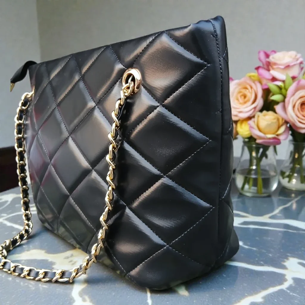 Detailed side view of Classic Quilted Chain Strap Tote Bag – Jet Black with elegant gold chain straps and soft padded quilted body