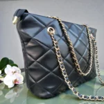 Side angle view of Classic Quilted Chain Strap Tote Bag – Jet Black highlighting structured shape diamond stitching and woven gold chain straps